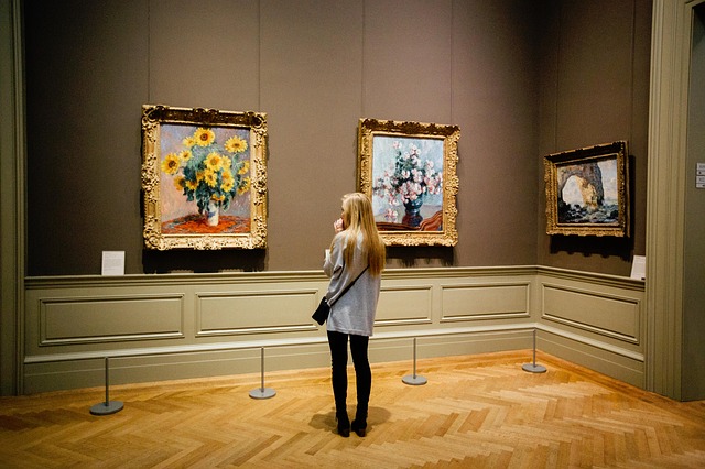 Foto van een vrouw in een museum voor een schilderij