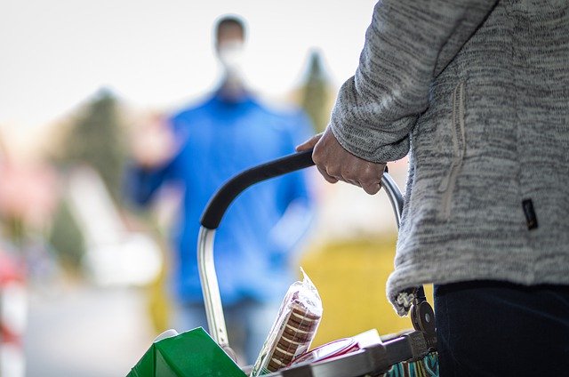 Foto van een persoon met een winkelmandje in de hand