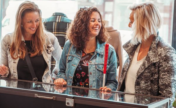 Foto van drie winkelende dames bij een vitrine