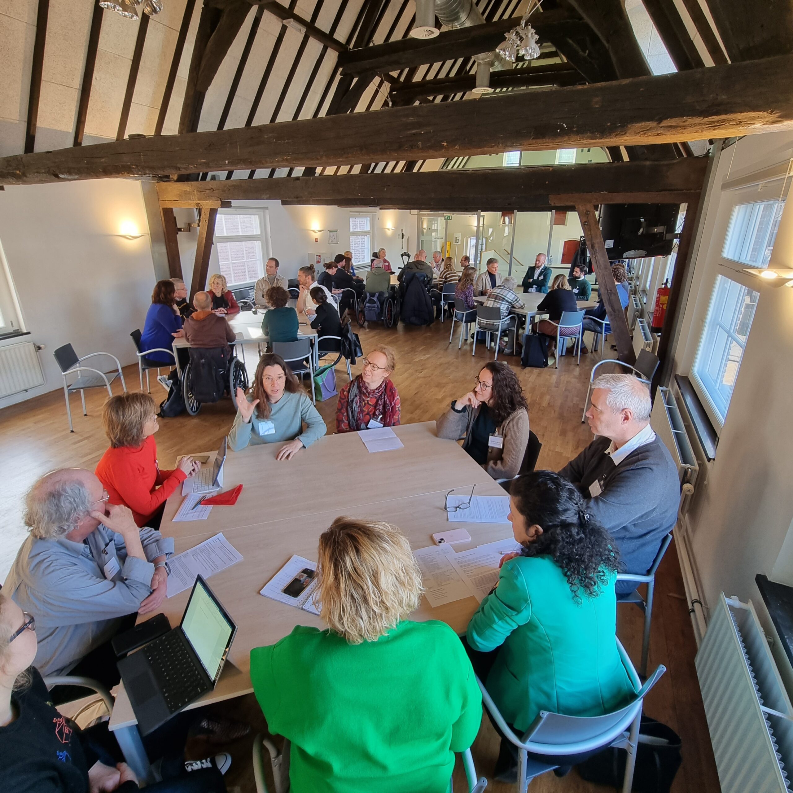 Overzichtsfoto van deelnemers van de bijeenkomst zittend aan een tafel