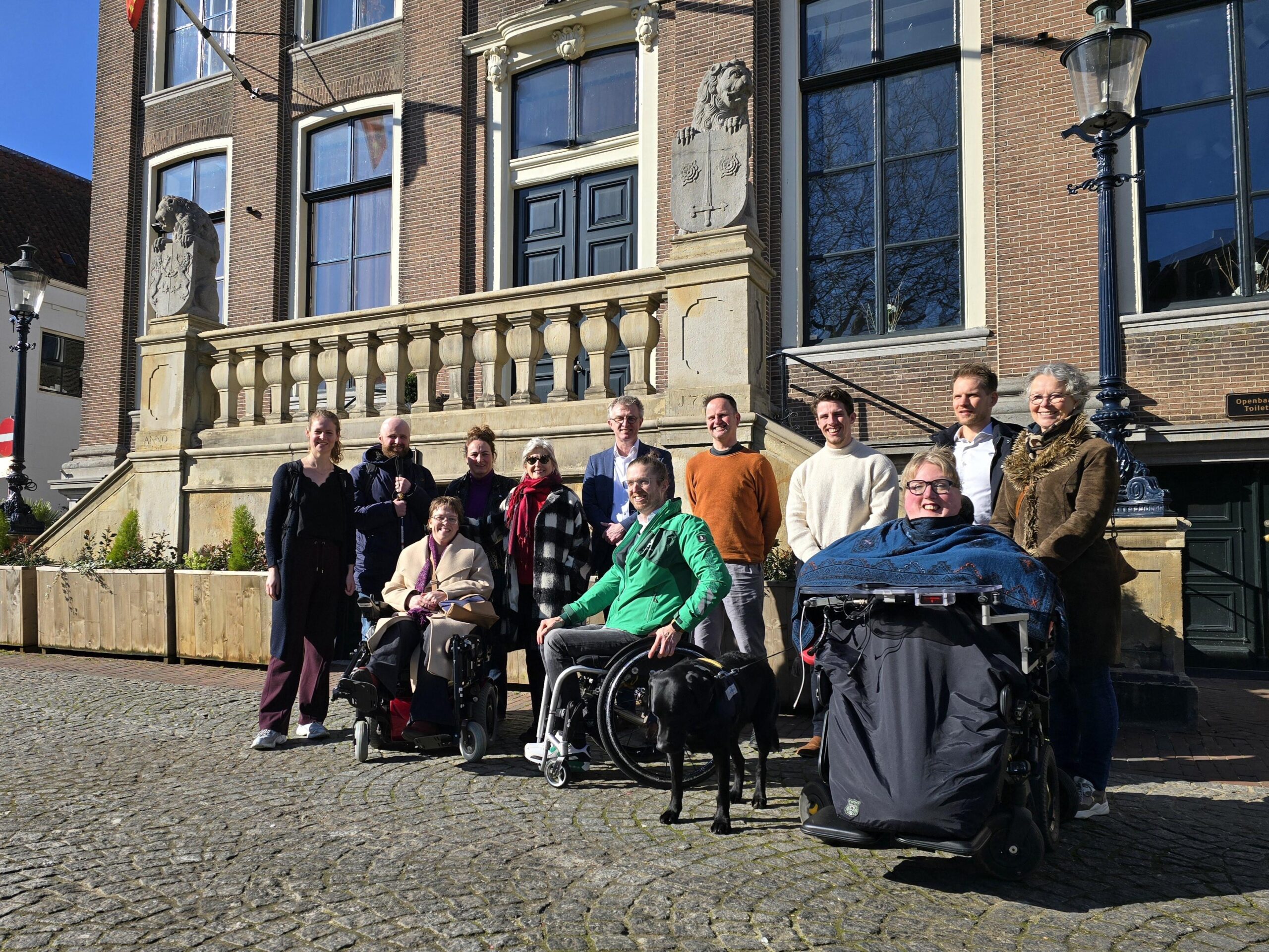 Foto van een groep mensen die voor het oude gemeentehuis van Zaltbommel staan