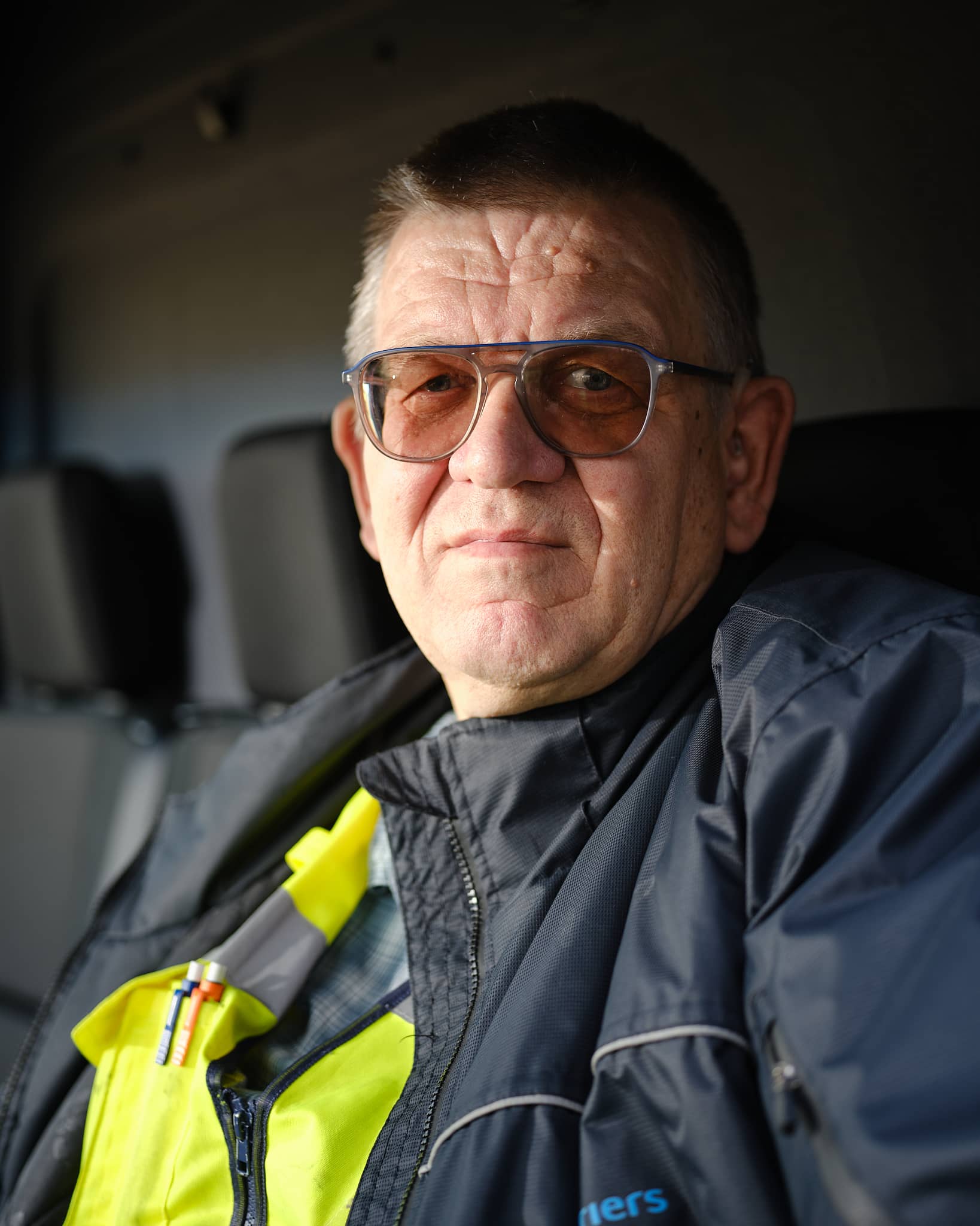 Portretfoto van Jan Smale een man met kort haar en een grote bril op zijn neus. Hij draagt een pak van de NS. 