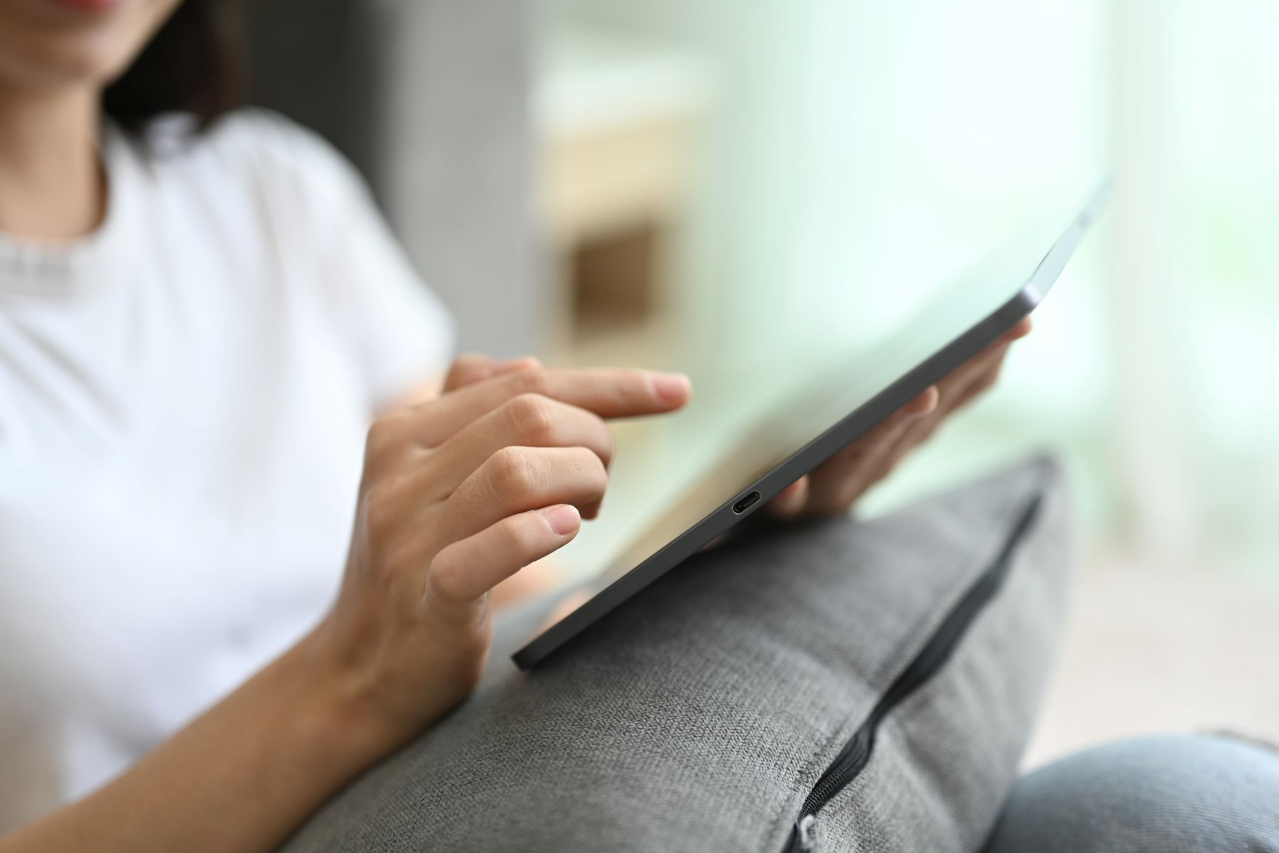 Foto van een vrouwenhand die wijst naar een scherm van een laptop